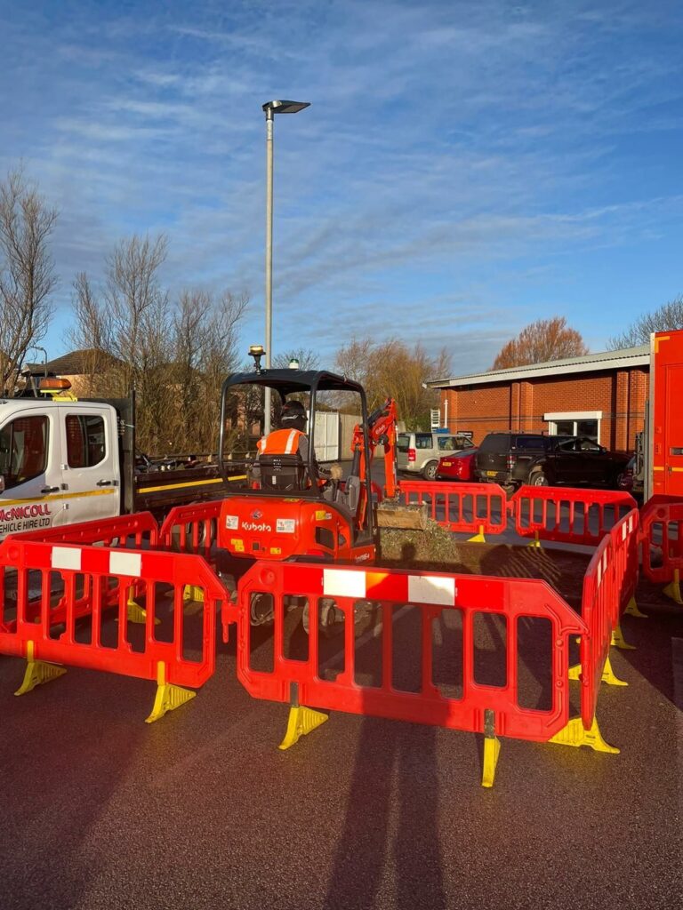 Mini excavator and barriers set up for civil engineering works in Barrow-in-Furness