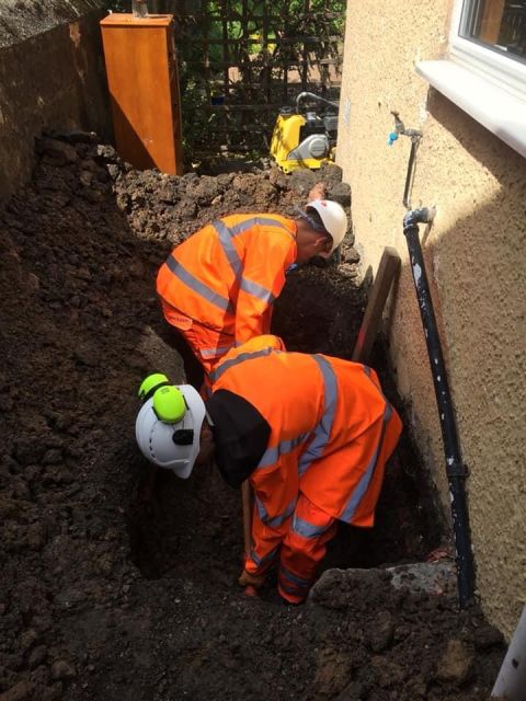 Operative replacing a lead water pipe beside a property in Alloa