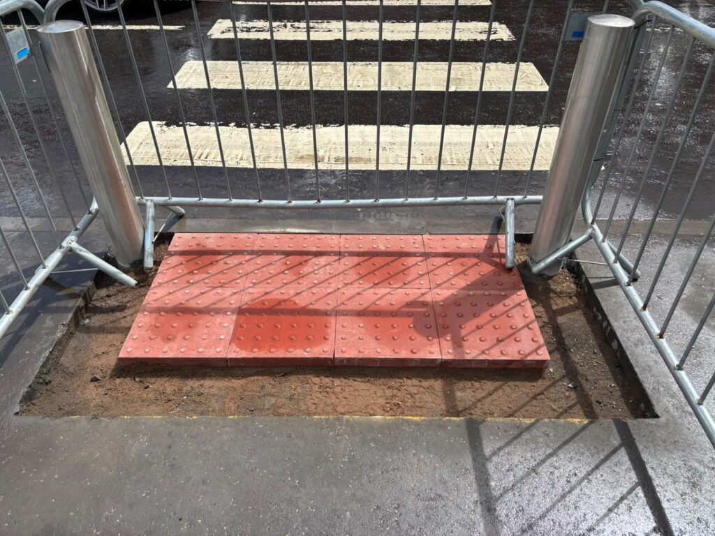 Red tactile paving slabs installed at a new pedestrian crossing in Bishopbriggs